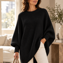Black oversized batwing sweater with round neck, ribbed trim, and asymmetric hem