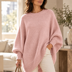 Pink oversized batwing sweater with round neck, ribbed trim, and asymmetric hem